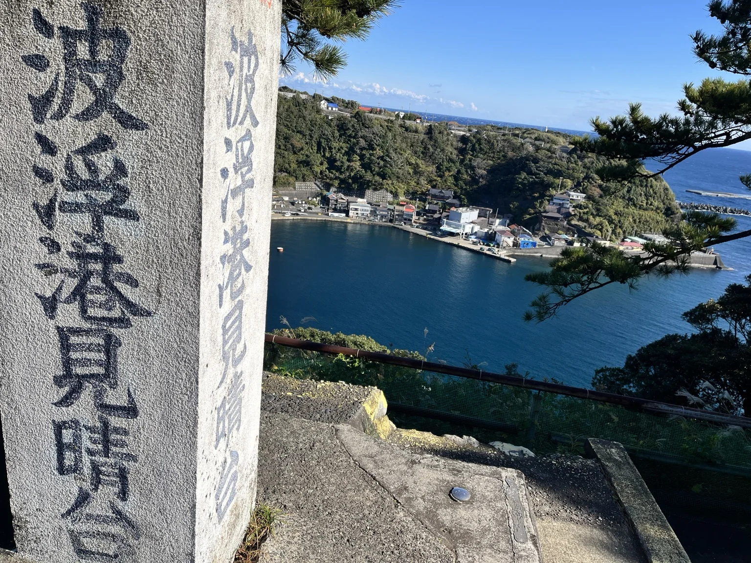 波浮港見晴台の石碑越しに望む波浮港